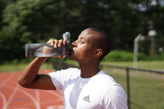 A Black Man Drinking Water from a Water Bottle