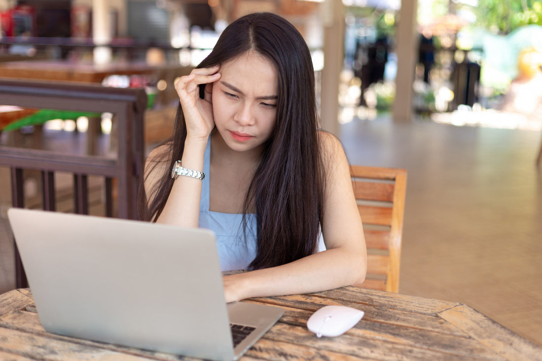woman experiencing a headache while looking at the computer